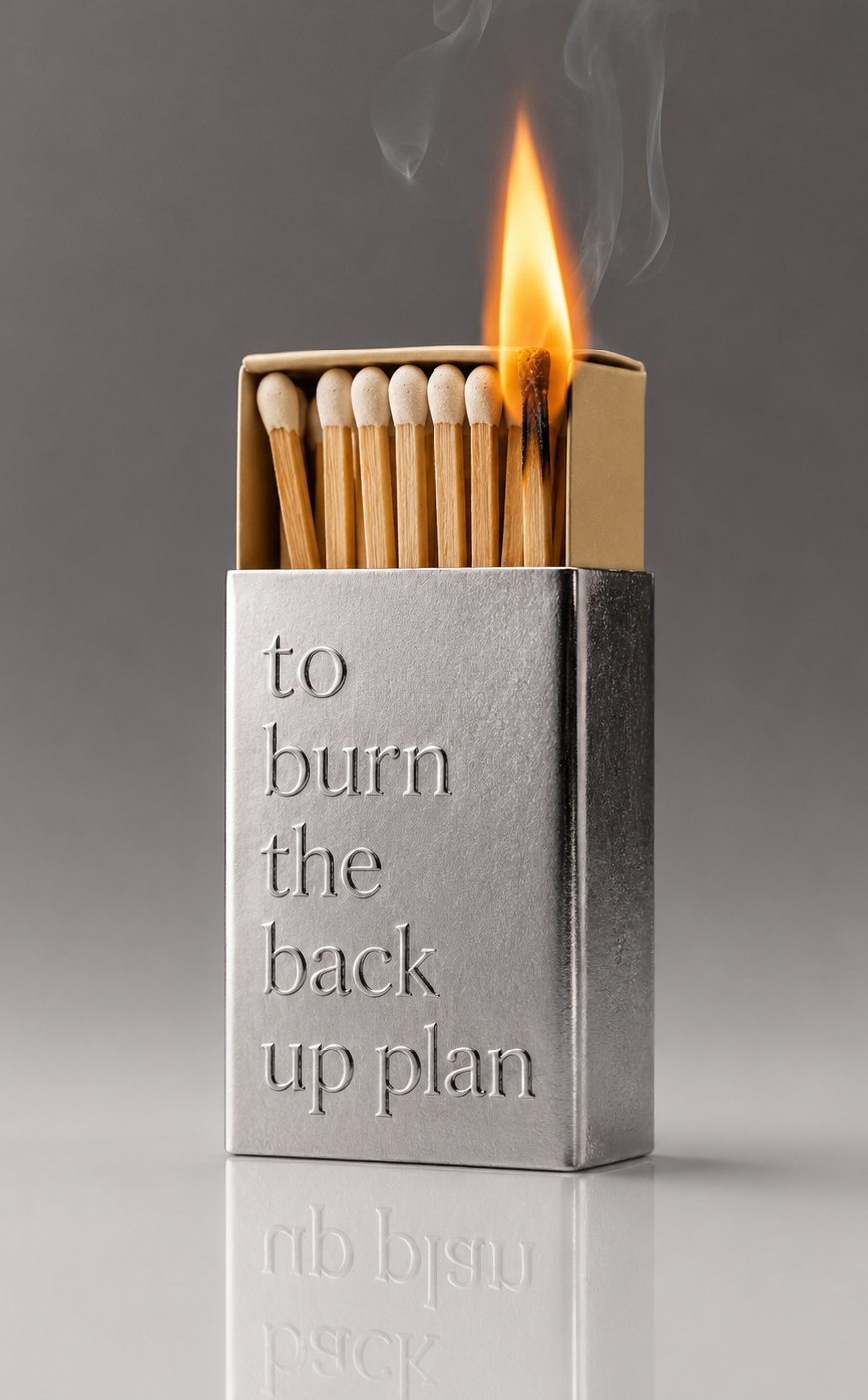 An engraved metal matchbox reading: to burn the back up plan